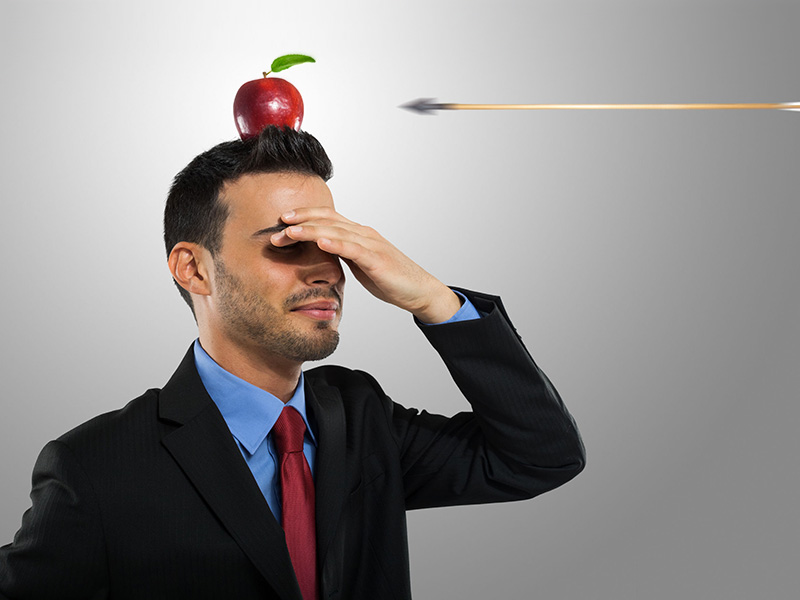 Flèche fonçant vers la pomme déposée sur la tête d'un homme d'affaires.